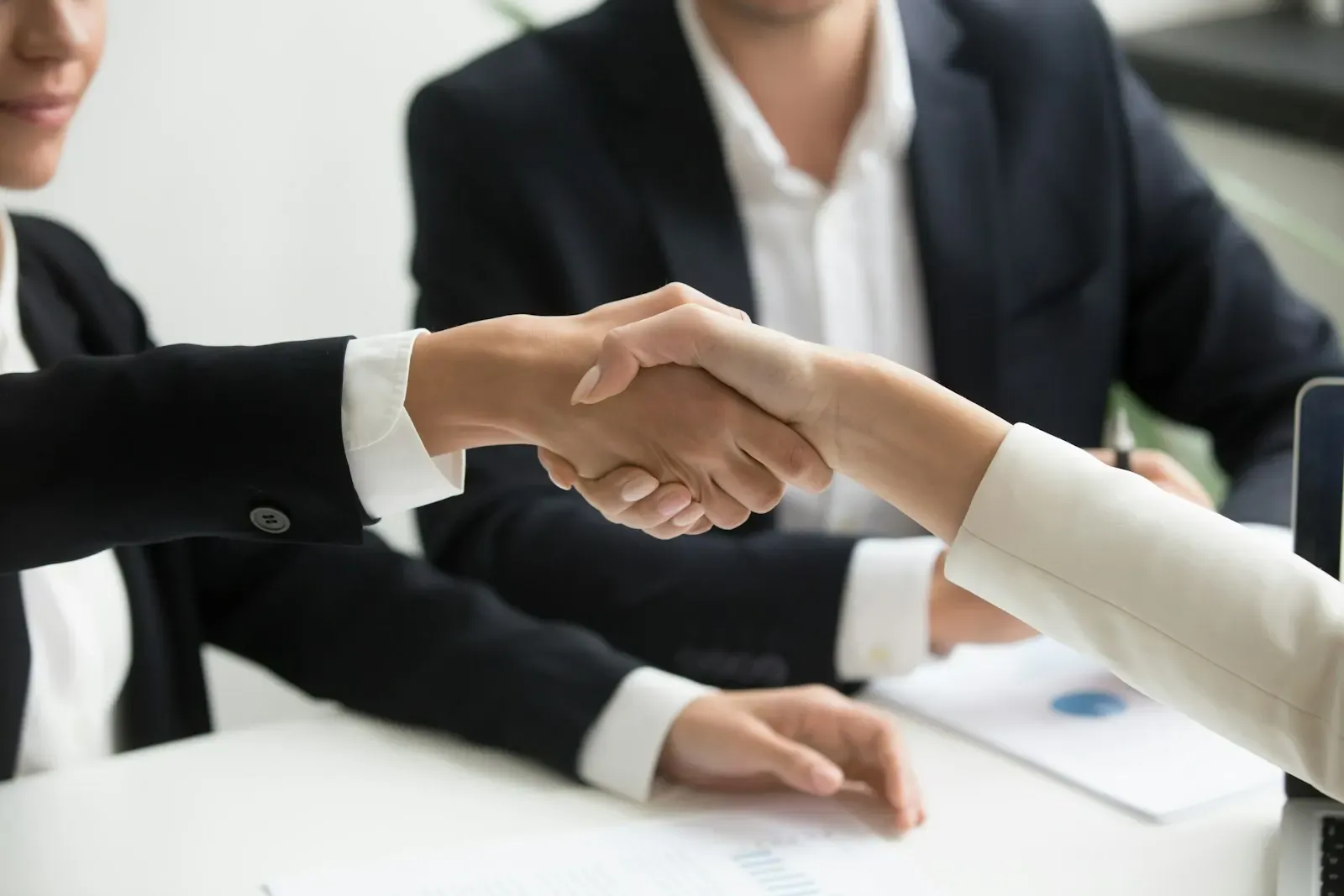 A manager and a client shaking hands during a meeting