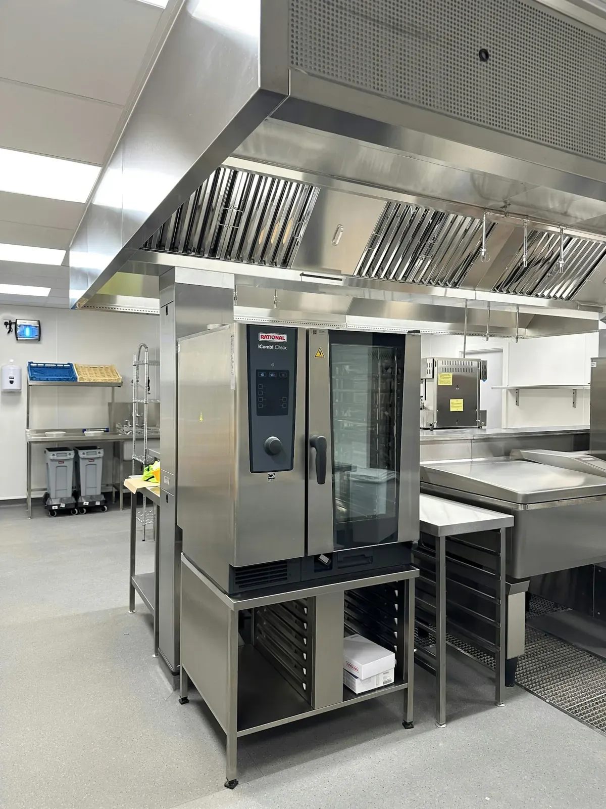 A professional kitchen with a combi oven and extractor hood
