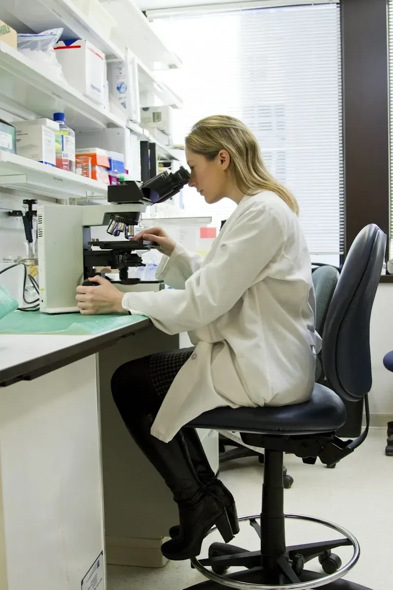 A specialist working with a microscope in a laboratory